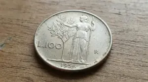Moneta italiana da 100 lire del 1956 su superficie in legno